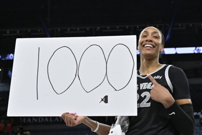 A'Ja Wilson posa con un cartel de '1000' por su récord.
