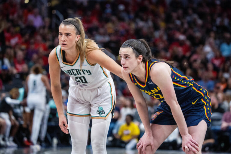 Caitlin Clark y Sabrina Ionescu esperan un tiro libre.
