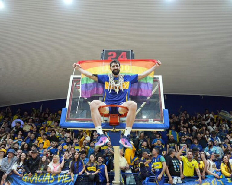 Sebastián Vega festeja arriba del aro de la Bombonerita con la bandera LGBTQ+