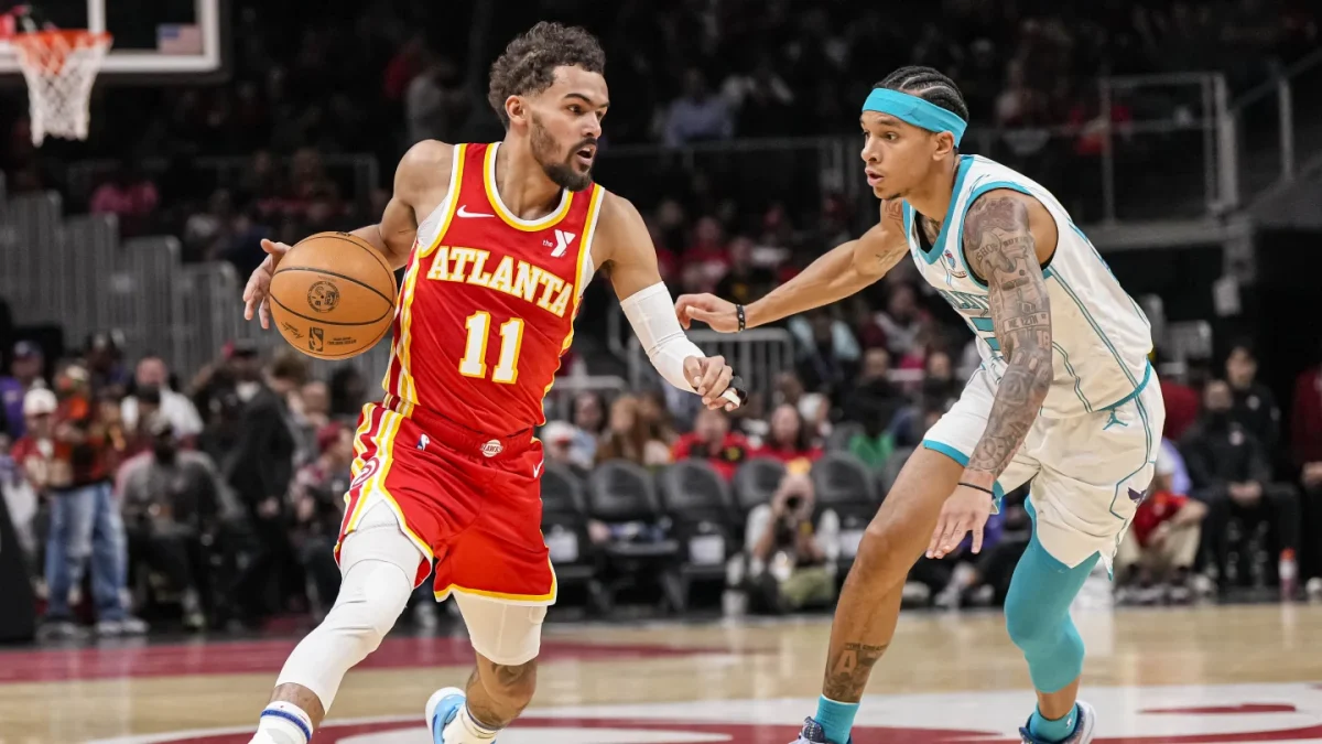 Trae Young lleva la pelota para los Atlanta Hawks en un juego contra los Charlotte Hornets.